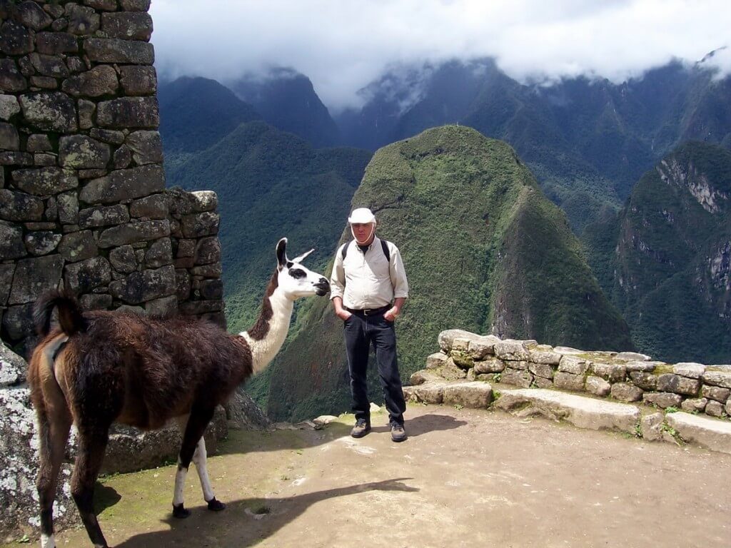 An image of Bob standing beside a Llama at Machu Picchu in Urubamba Province, Peru.
