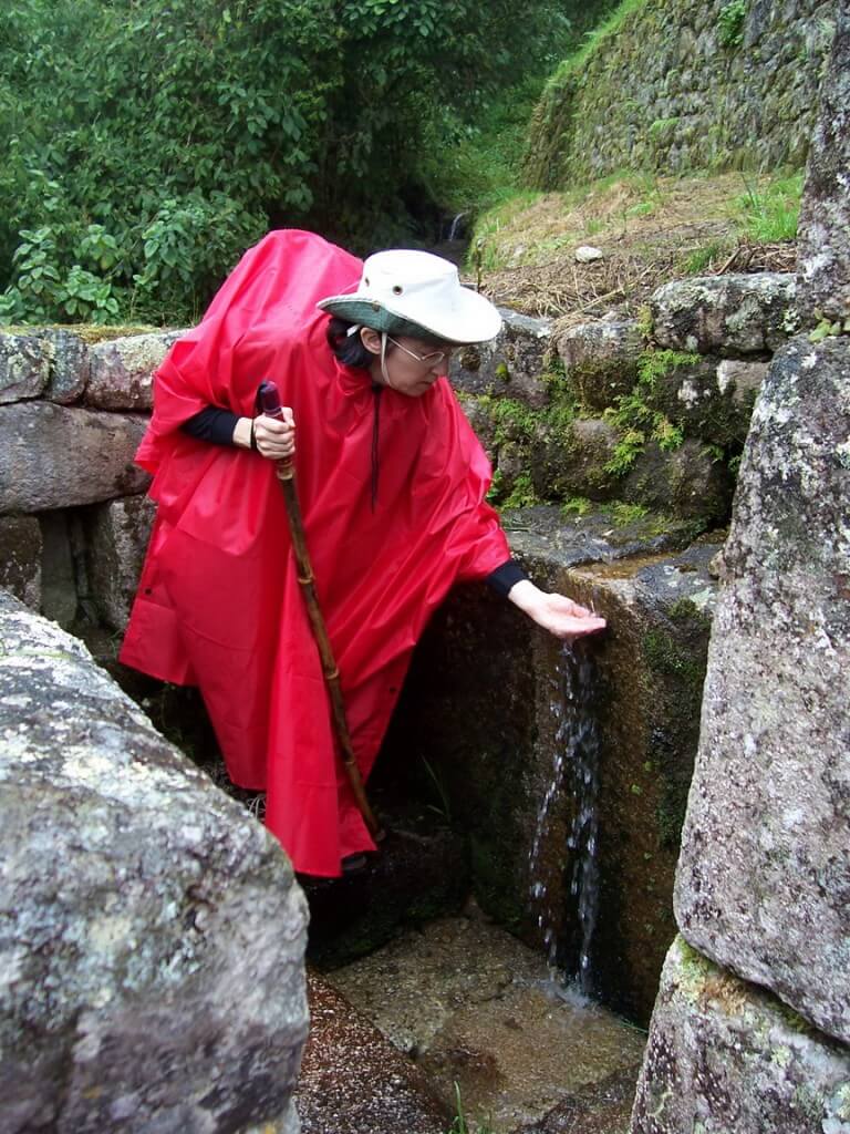 Jean gathers water at the stream in the Wiñay Wayna ruins in Peru, South America
