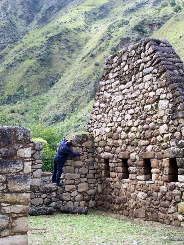 Worker repairs the stone walls at the Inca ruins at Chachabamba in Peru, South America