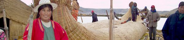 photograph of a Uros men building a new reed boat on a Uros floating island on Lake Titicaca in Peru, South America.