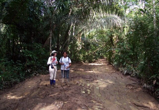 Jean and Sonja stop for a quick break on muddy Amazon trail