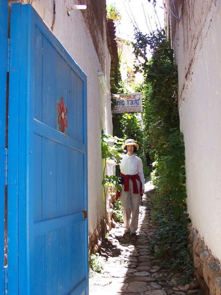 jean stands in a narrow laneway, cusco, peru