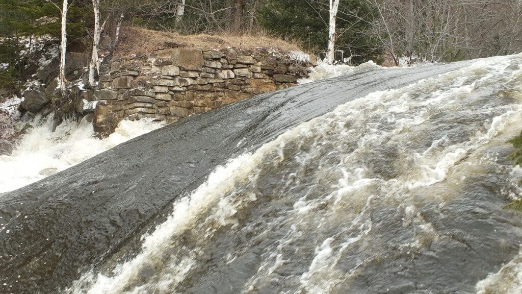 Marsh's Falls flooding - water gushing from beneath far rock bank - Oxtongue river - April 20 2013