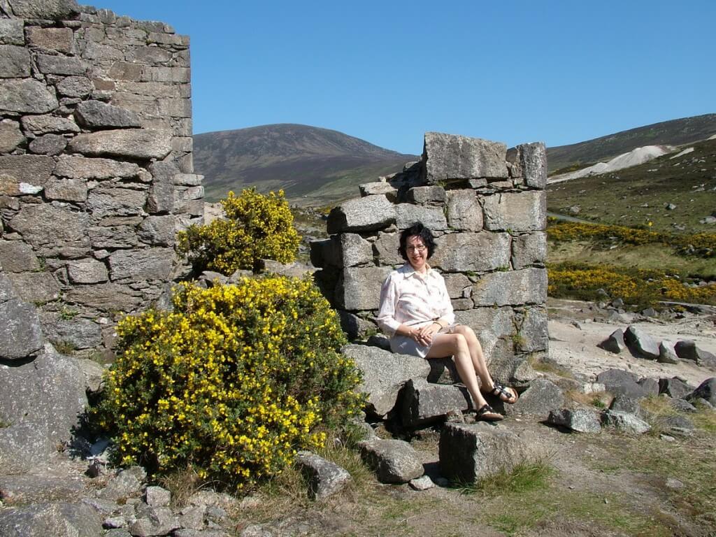 jean sits beside miners village ruins - glendalough - wicklow - ireland