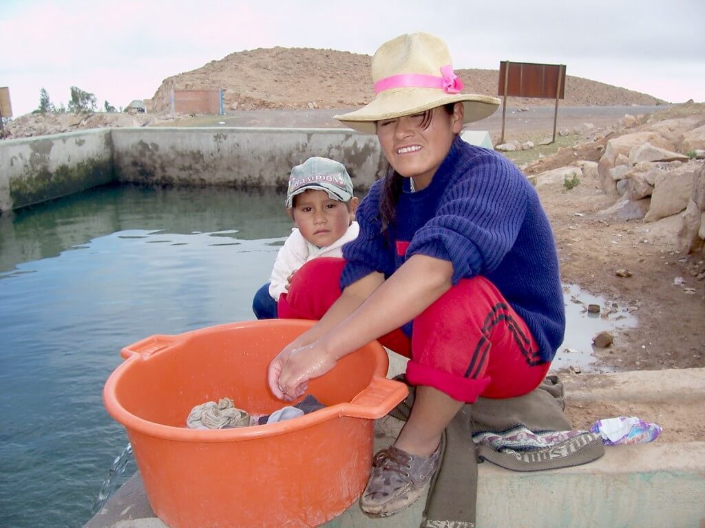 Woman washes her clothes at the public reservoir in Nuevo Santiago, Peru, South America