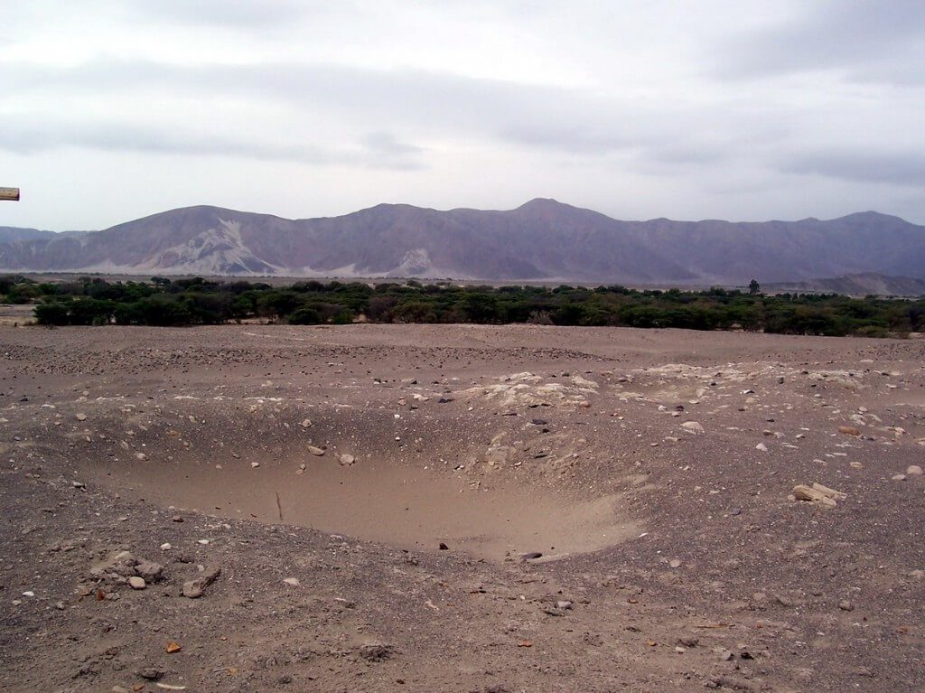 A pit in the desert at the Chauhilla Cemetery near Nazca in Peru, South America.