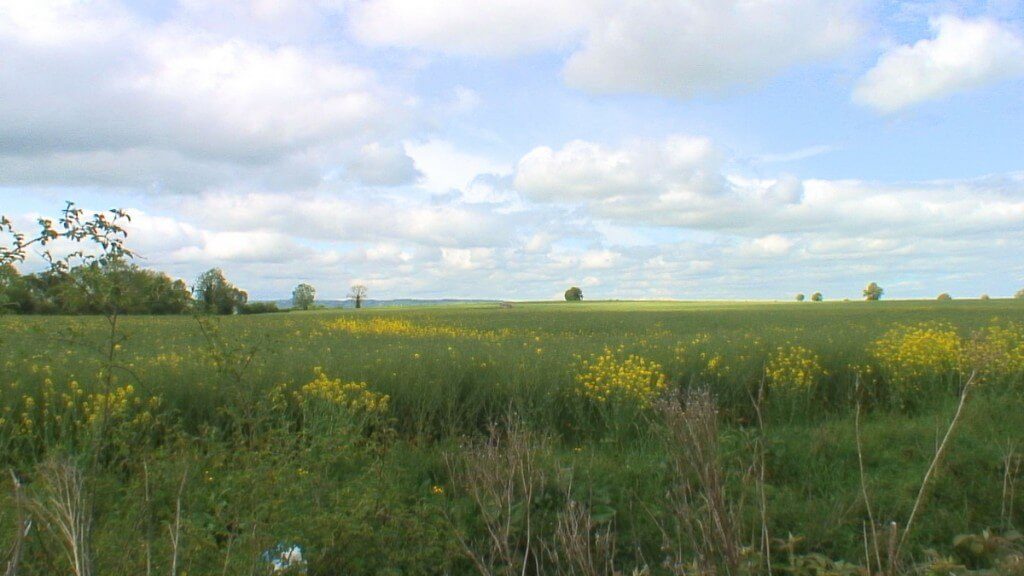 An image of clouds above a farm field near the Brownshill Portal Tomb in County Carlow, Ireland. Photography by Frame To Frame - Bob and Jean.