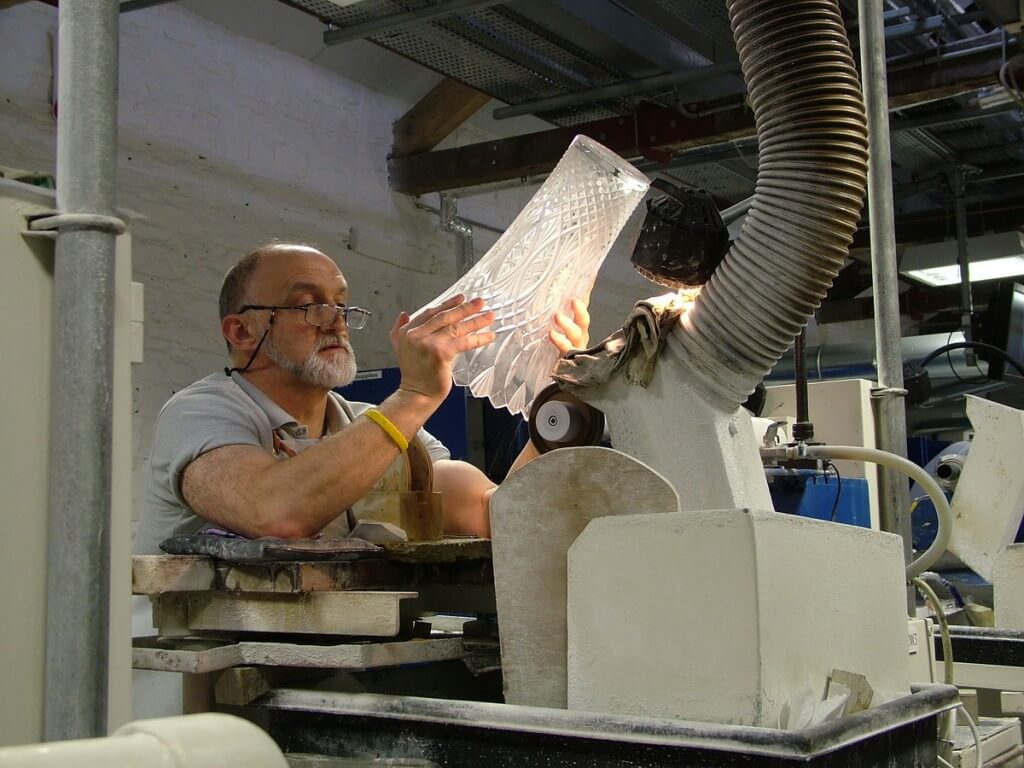 An image of a master cutter, cutting a vase at the Waterford Crystal factory in Waterford, Ireland. Photography by Frame To Frame - Bob and Jean.