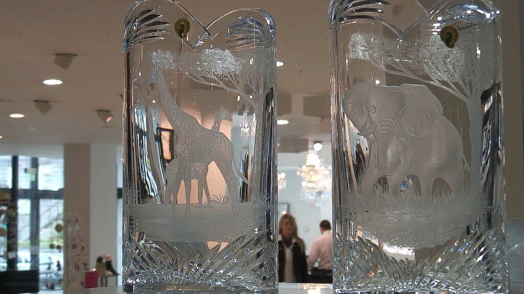 An image of two crystal vases with Elephants and Giraffe on them at House of Waterford Crystal in Waterford, Ireland. Photography by Frame To Frame - Bob and Jean.