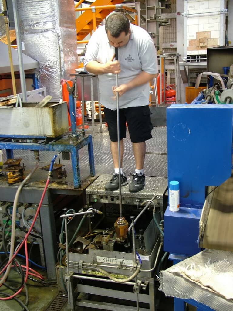 An image of a glass blower, blowing glass at the Waterford Crystal factory in Waterford, Ireland. Photography by Frame To Frame - Bob and Jean.