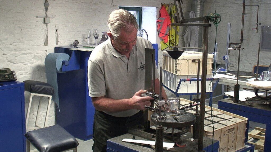 An image of a craftman hand marking a glass with ink for cutting at the Waterford Crystal factory in Waterford, Ireland. Photography by Frame To Frame - Bob and Jean.