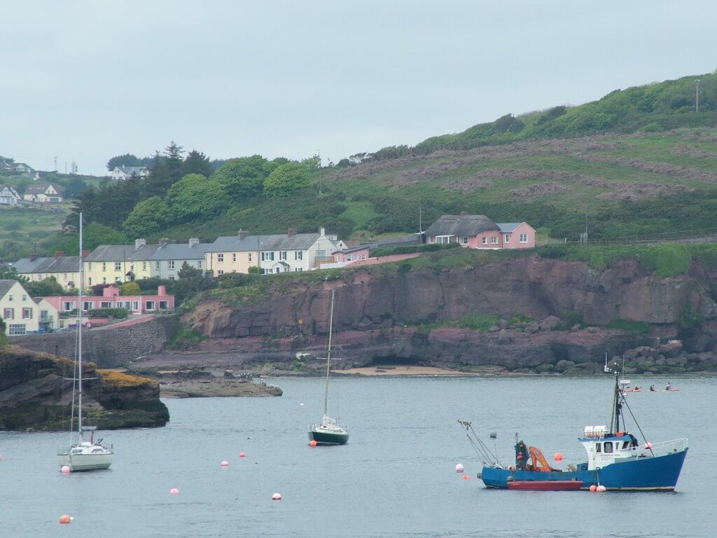 houses sitting along shoreline at dunmore east in county waterford - ireland