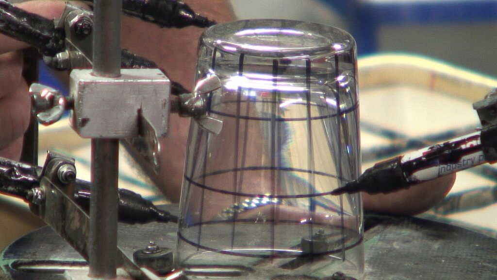 An image of a glass being ink marked for cutting at the Waterford Crystal factory in Waterford, Ireland. Photography by Frame To Frame - Bob and Jean.