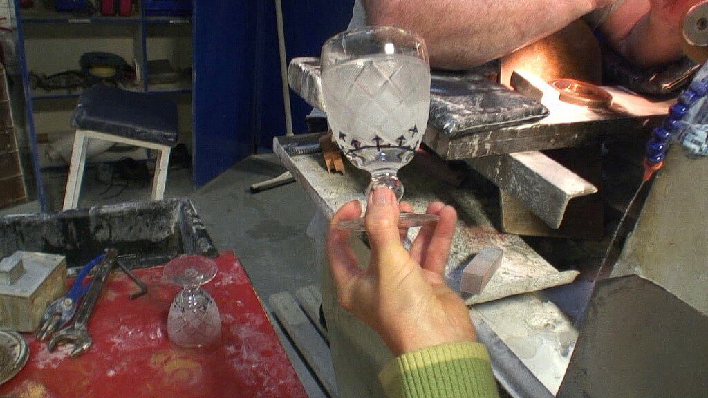 An image of Jean holding a crystal goblet awaiting cutting at the Waterford Crystal factory in Waterford, Ireland. Photography by Frame To Frame - Bob and Jean.