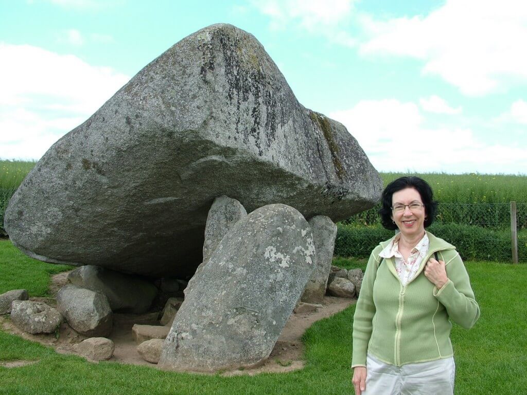  An image of Jean standing in front of the Brownshill Portal Tomb in County Carlow, Ireland. Photography by Frame To Frame - Bob and Jean.
