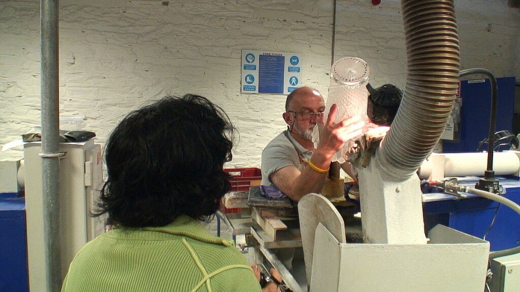 An image of Jean watching a master cutter cutting a vase at the Waterford Crystal factory in Waterford, Ireland. Photography by Frame To Frame - Bob and Jean.