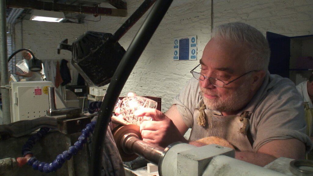 An image of a glass cutter, cutting a goblet at the Waterford Crystal factory in Waterford, Ireland. Photography by Frame To Frame - Bob and Jean.