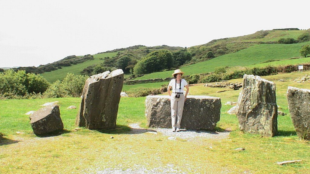 An image of Jean leaning againt the Recumbent axial stone at the Drombeg Stone Circle in County Cork, Ireland. Photography by Frame To Frame - Bob and Jean