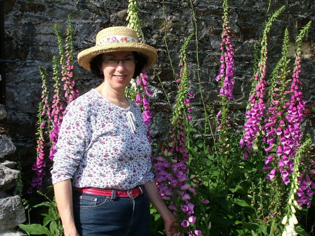 Jean standing beside Foxglove which is growing in a flower garden at Blarney Castle in County Cork, Ireland