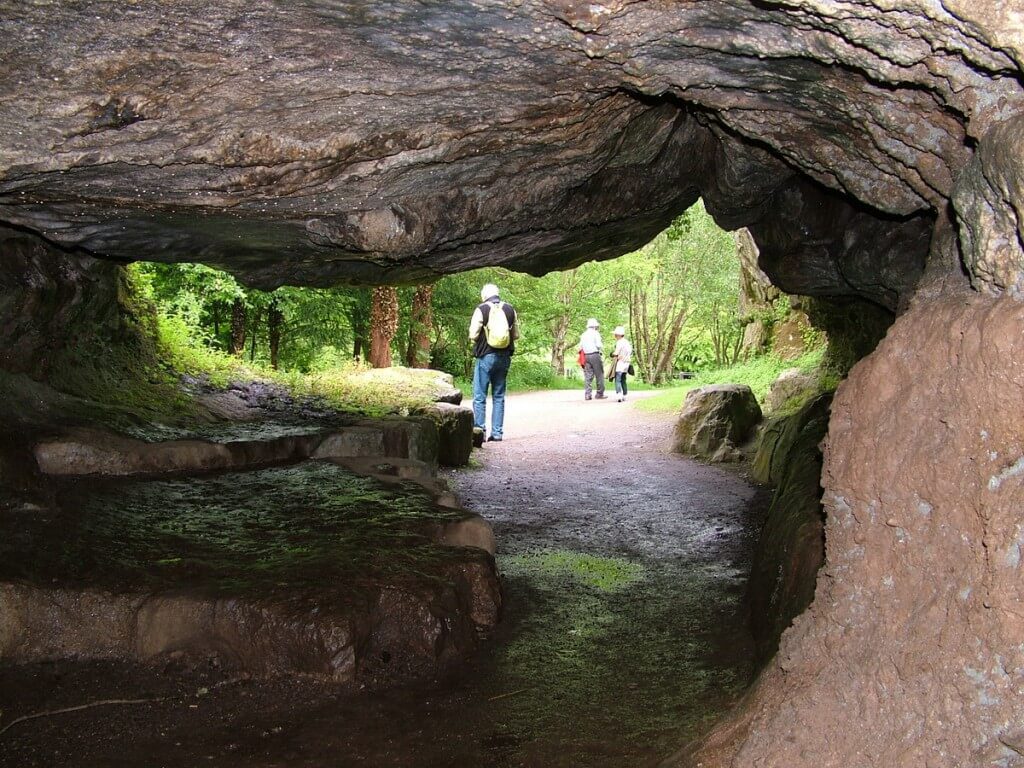 An image looking out of Badgers Cave to the green world outside at Blarney Castle in Ireland. Photography by Frame To Frame - Bob and Jean.