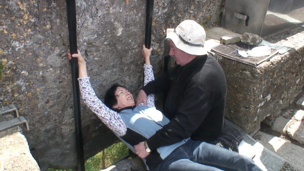 An image of Jean preparing to Kiss the Blarney Stone at Blarney Castle in Ireland. Photography by Frame To Frame - Bob and Jean.