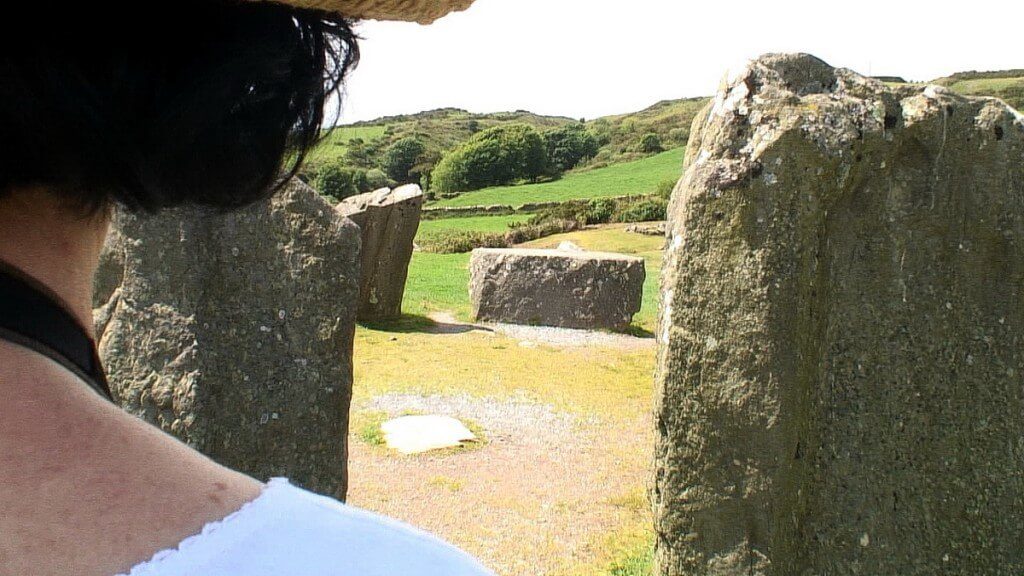 An image of Jean looks at the recumbent axial stone at the Drombeg Stone Circle in County Cork, Ireland. Photography by Frame To Frame - Bob and Jean 