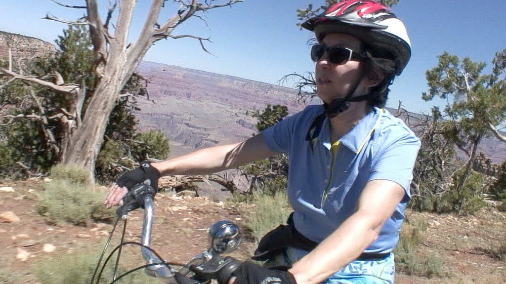 Jean riding a bike along the South Rim at Hermit's Rest at Grand Canyon National Park in Arizona, U.S.A.
