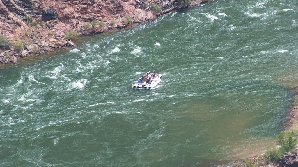 people rafting on the colorado river below plateau point at the grand canyon
