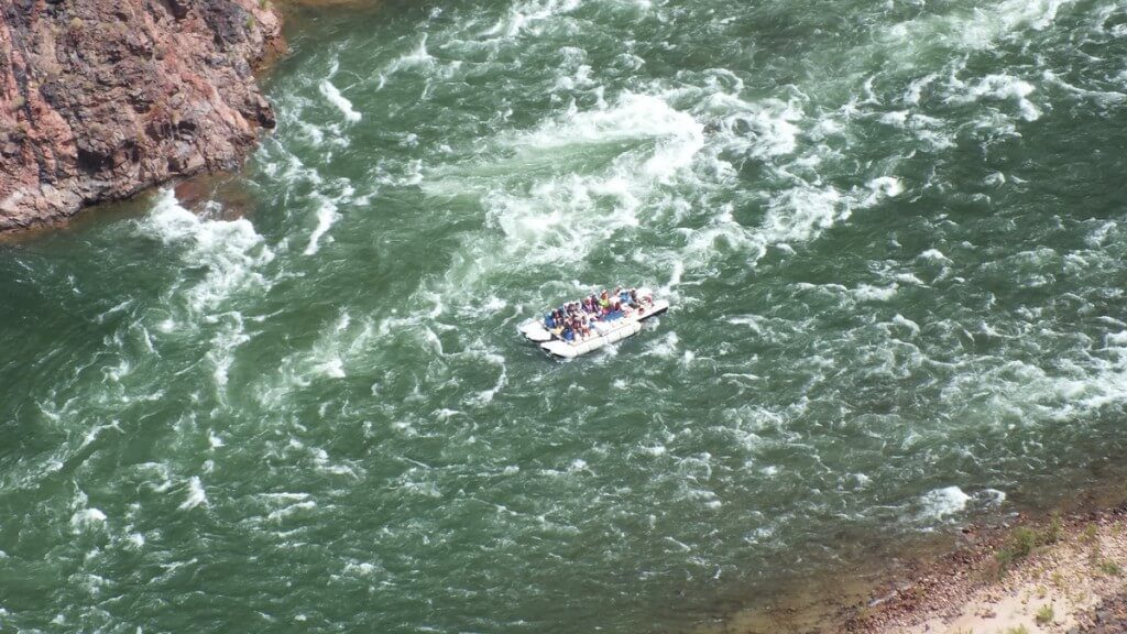 people rafting on the colorado river below plateau point at the grand canyon