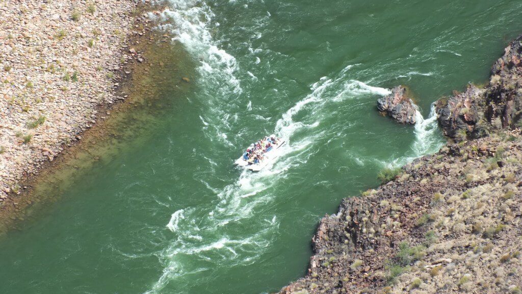 people rafting on the colorado river below plateau point at the grand canyon