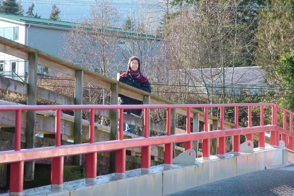 An image of Jean standing on the dock at Fanny Bay on Vancouver Island. Photography by Frame To Frame - Bob and Jean