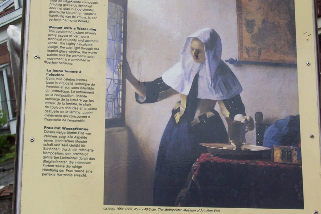 vermeer work of art - woman with a water jug - public sign in delft - netherlands