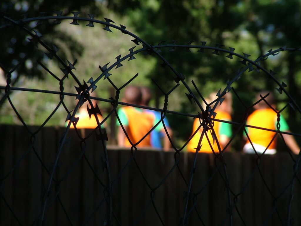 Children playing behind school razor wire in Sabie, South Africa