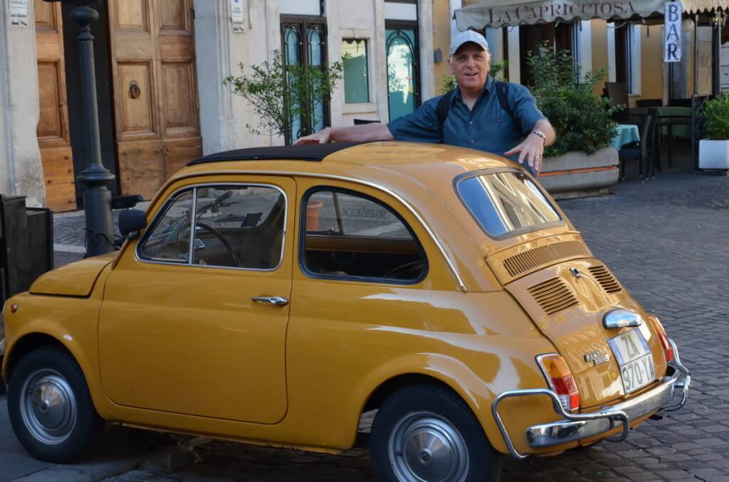 Bob beside a yellow Fiat in Rome, Italy