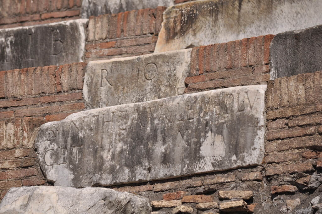 An image of inscriptions carved on marble blocks at the Colosseum in Rome, Italy. Photography by Frame To Frame - Bob and Jean.