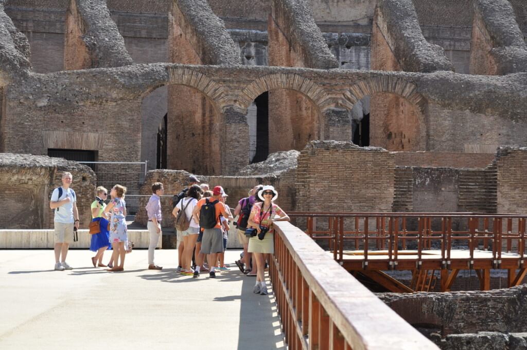 An image of Jean standing on the restored wooden floor of the Roman Colosseum in Rome, Italy. Photography by Frame To Frame - Bob and Jean.