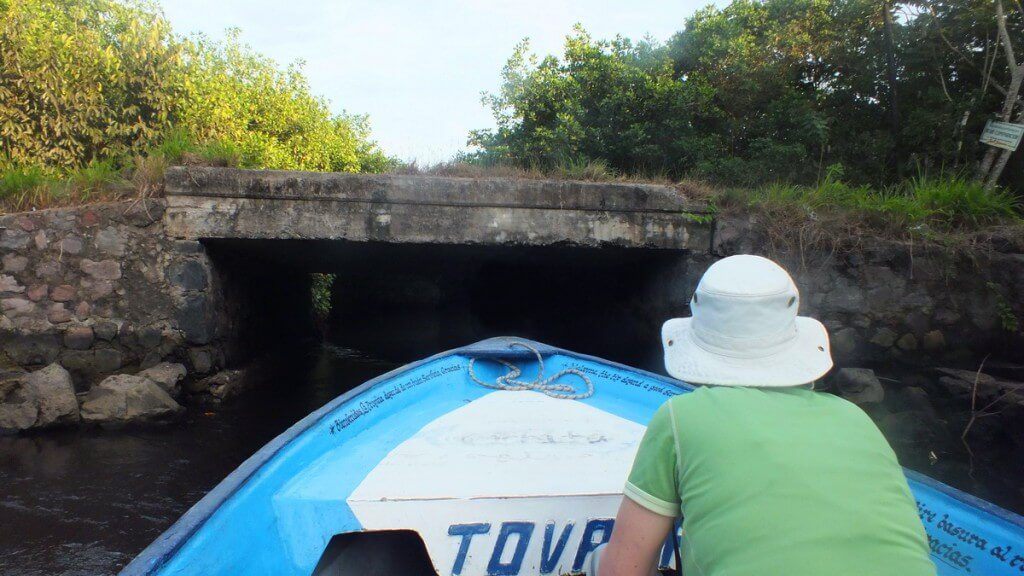 Photo of a boat approaching a channel under a bridge in the mangrove swamp near San Blas, Mexico
