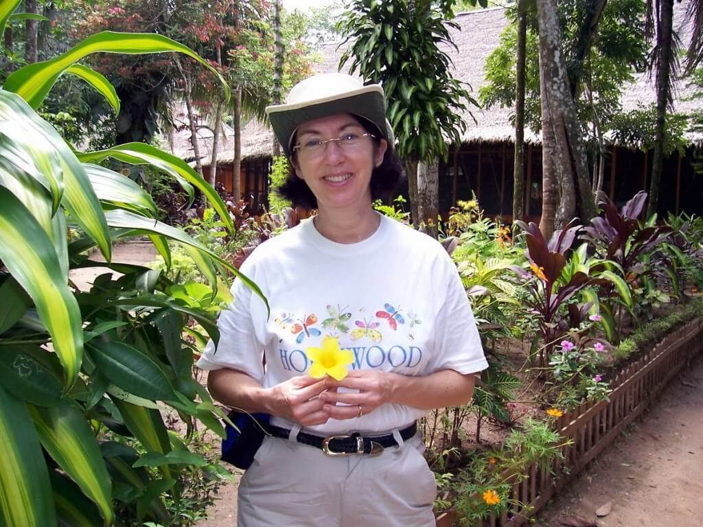 Jean holding yellow flower at Sandoval Lake lodge, Lake Sandoval, Amazon Basin, Peru