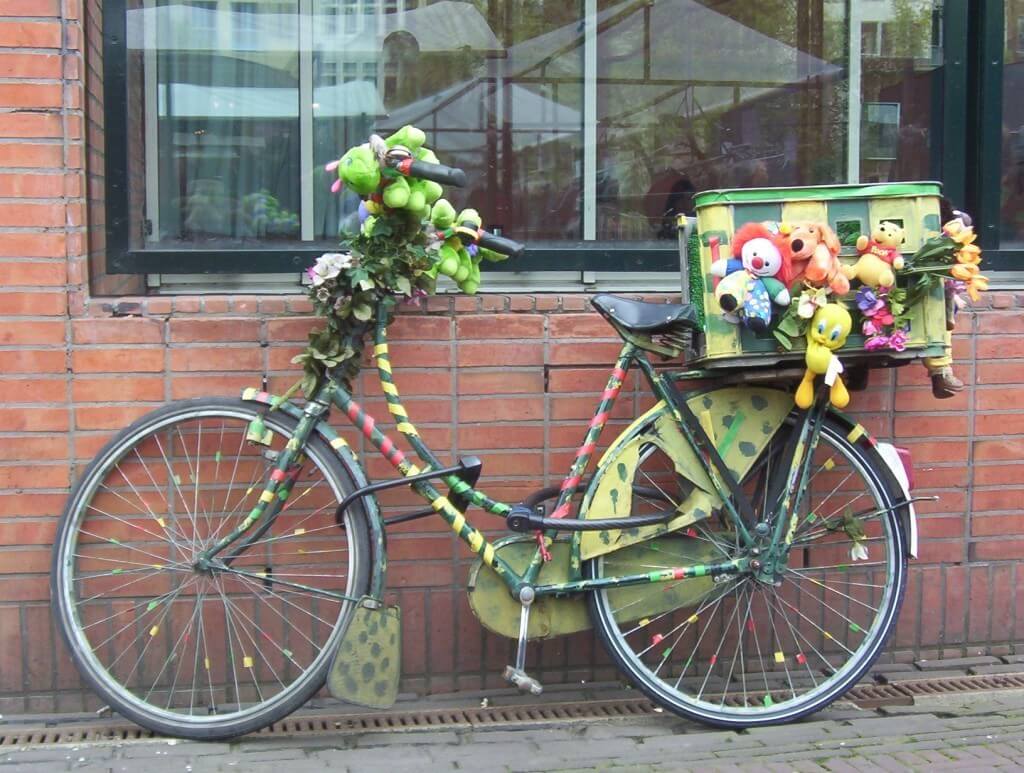 green colored bike with toys in amsterdam, the netherlands