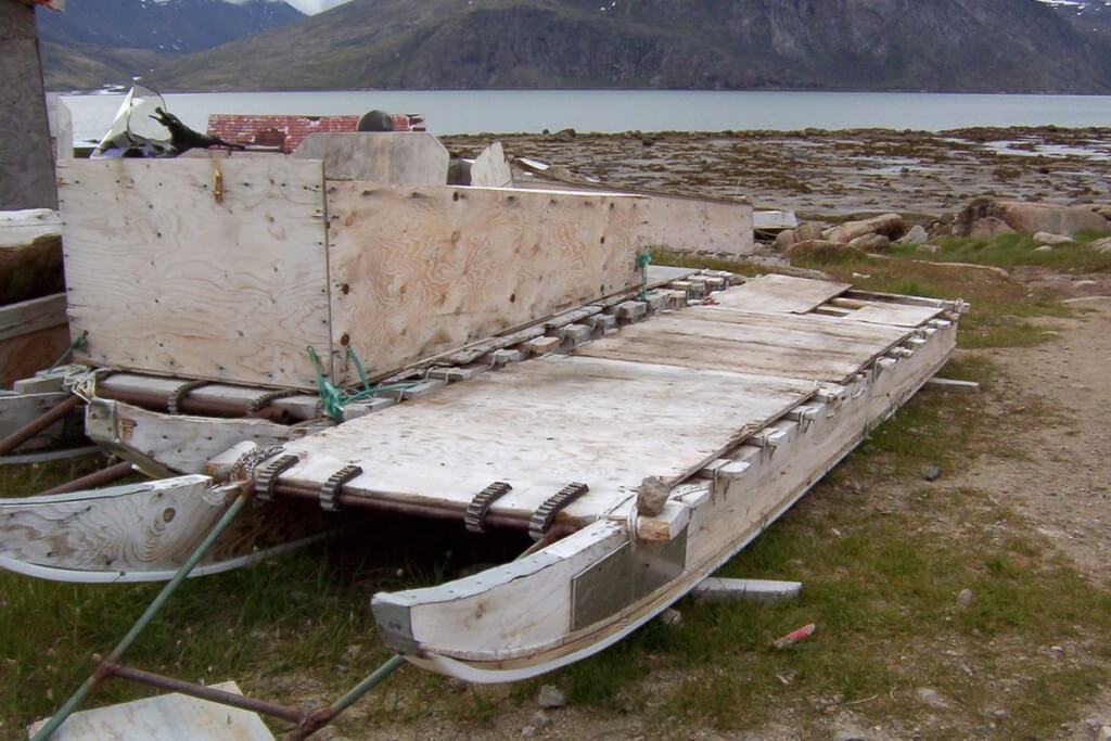 photograph of inuit toboggans sitting on the grass in Pangnirtung, Nunavut, Canada.