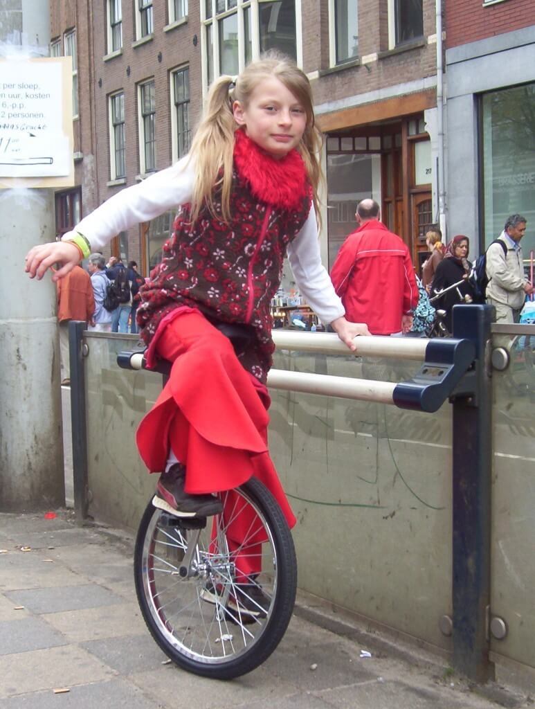 young girl on unicycle, amsterdam, the netherlands