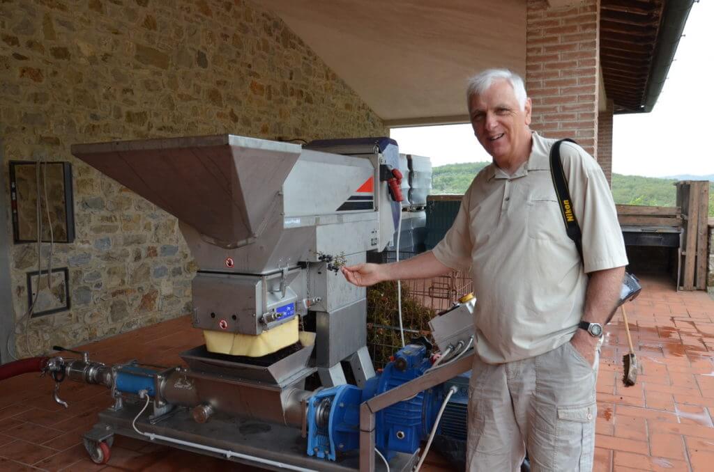 bob beside the grape crusher at il colombaio di cencio vineyard, gaiole in chianti, itay
