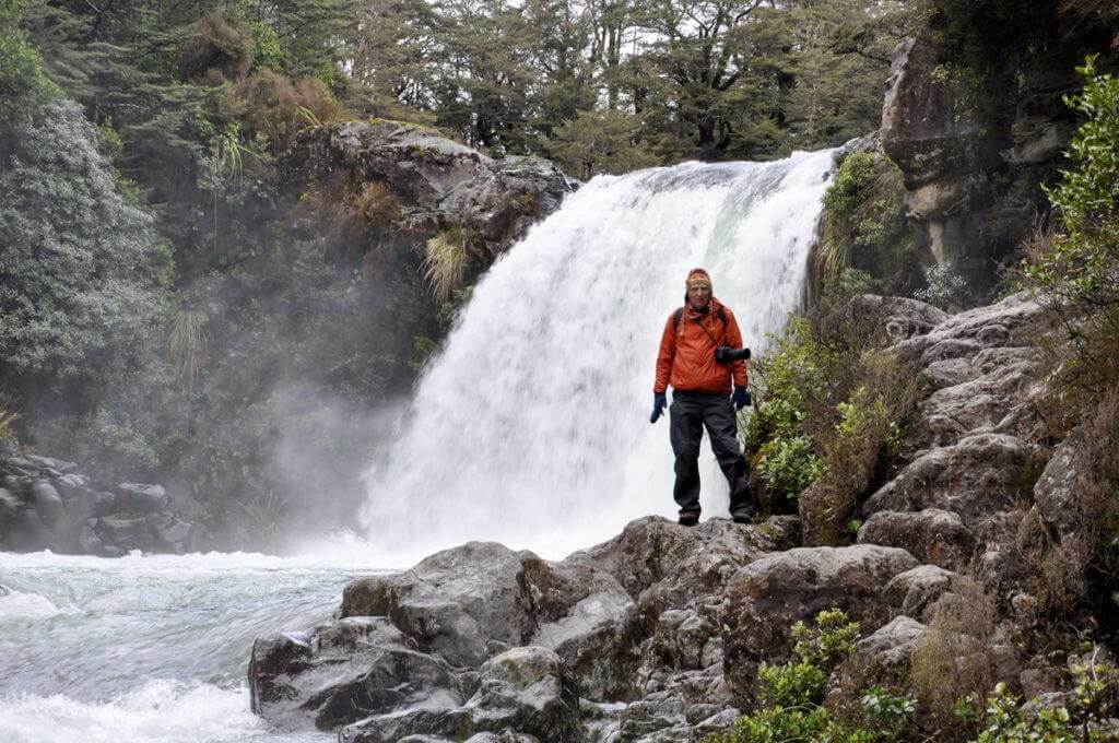 An image of Bob standing below Tawhai Falls in Tongariro National Park in New Zealand. Photography by Frame To Frame - Bob and Jean.