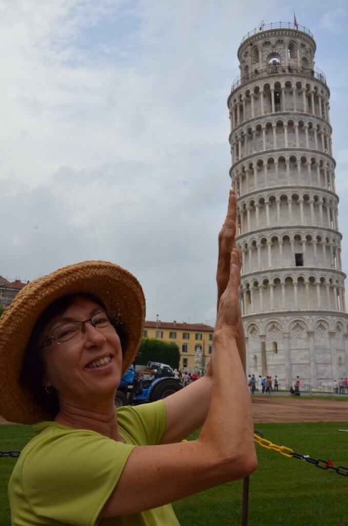 An image of Jean pretending to hold up the Leaning Tower of Pisa in Tuscany, Italy. Photography by Frame To Frame - Bob and Jean.