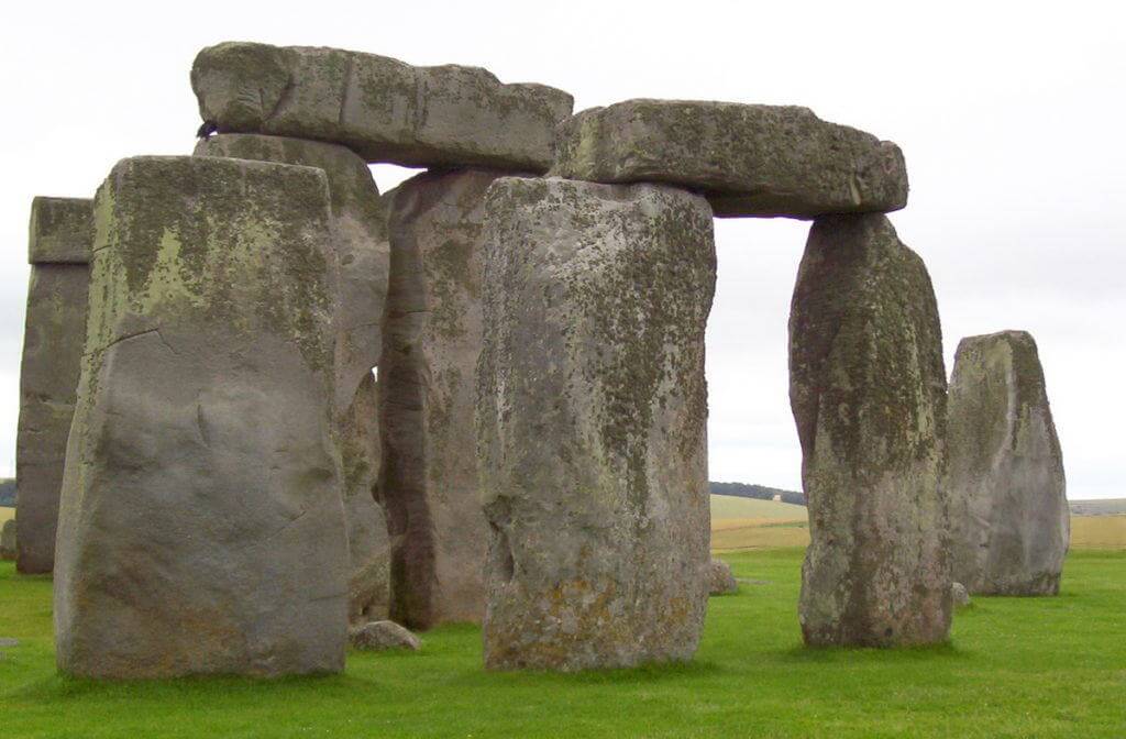 An image of massive stone pillars holding up two lintel stones at Stonehenge in Wiltshire at dusk in England. Photography by Frame To Frame - Bob and Jean
