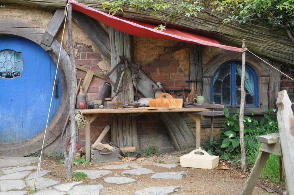 An image of various woodworking tools sitting on a bench in front of the carpenters hobbit hole at Hobbiton in New Zealand. Photography by Frame To Frame - Bob and Jean.