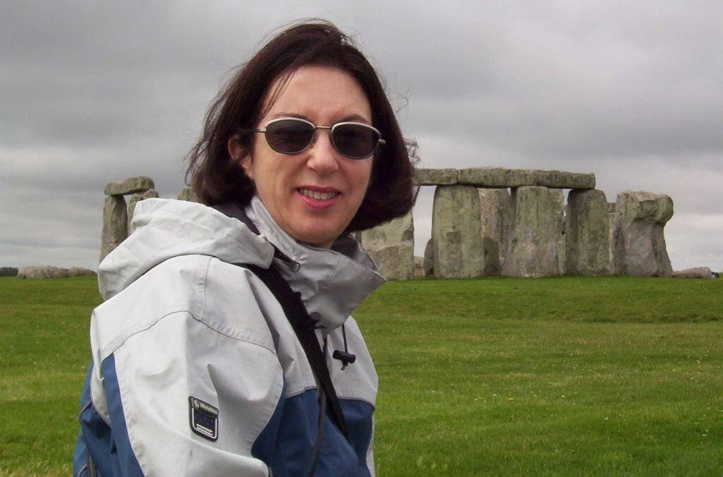 An image of Jean standing in front of Stonehenge in Wiltshire, England. Photography by Frame To Frame - Bob and Jean