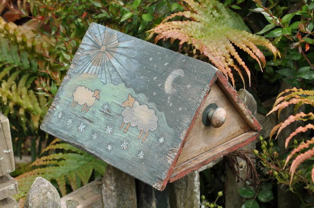 An image of a mail box with sheep painted on it at Hobbiton in New Zealand. Photography by Frame To Frame - Bob and Jean.