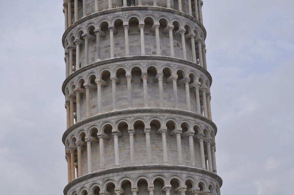 A image of the white stone walls of the Leaning Tower of Pisa in Tuscany, Italy. Photography by Frame To Frame - Bob and Jean. 