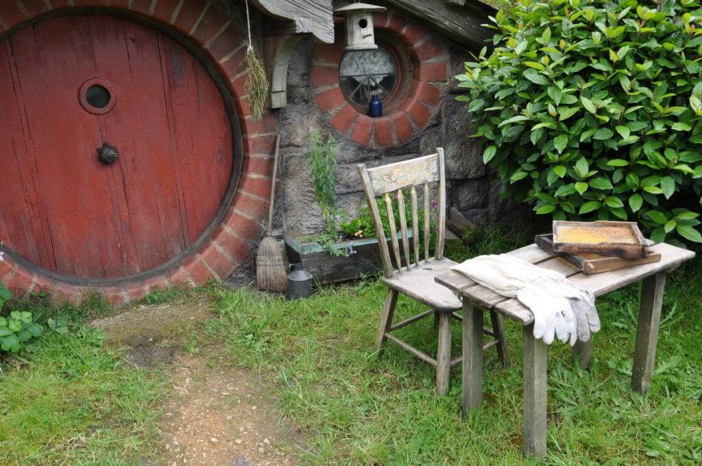 An image of a small table with bee keeper gloves and two honeycombs on it at the home of the beekeeper in Hobbiton in New Zealand. Photography by Frame To Frame - Bob and Jean.